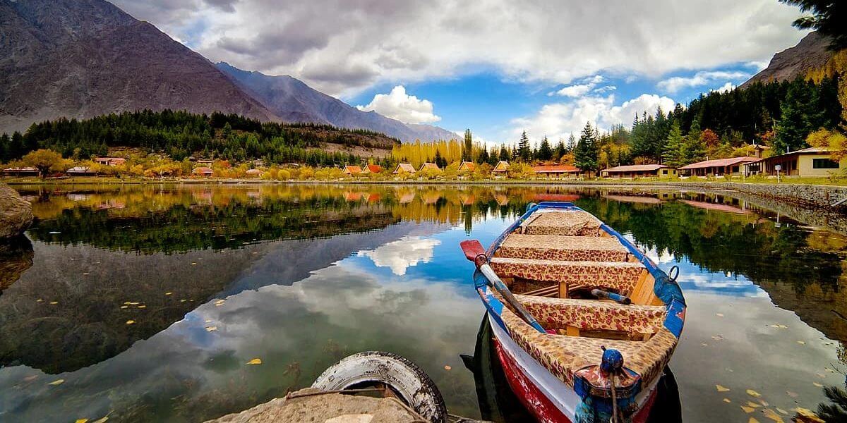 Wooden boat moored on a still lake in autumn, Skardu