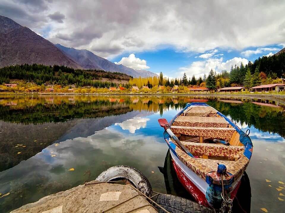 Wooden boat moored on a still lake in autumn, Skardu