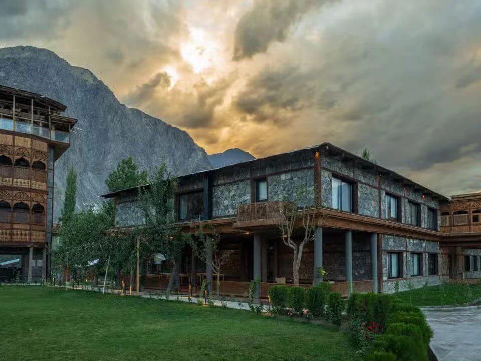 Stone and timber hotel at dusk below the Karakoram, Skardu